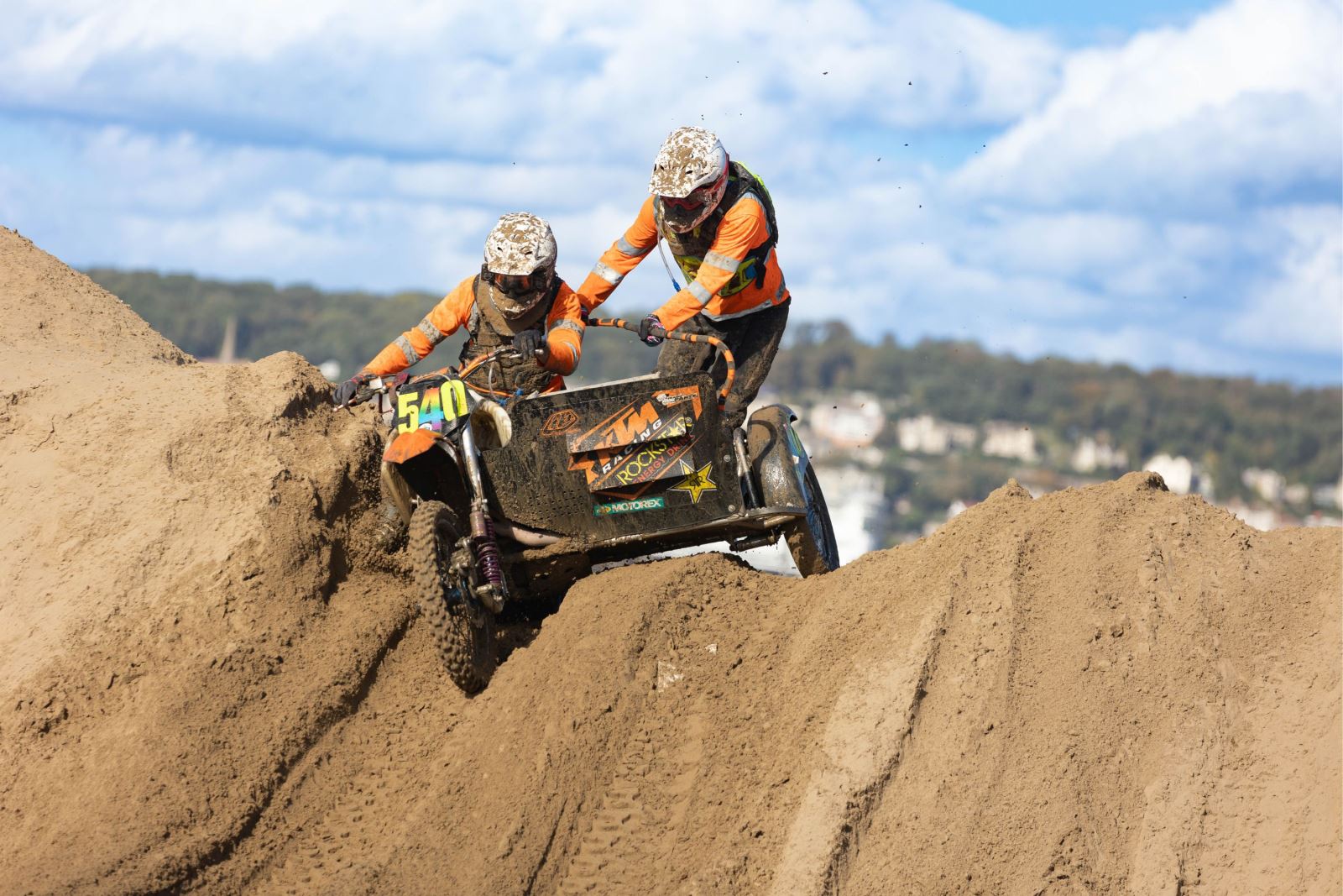 A motorbike and sidecar at the top of a sand dune during the Weston-super-Mare Beach Race